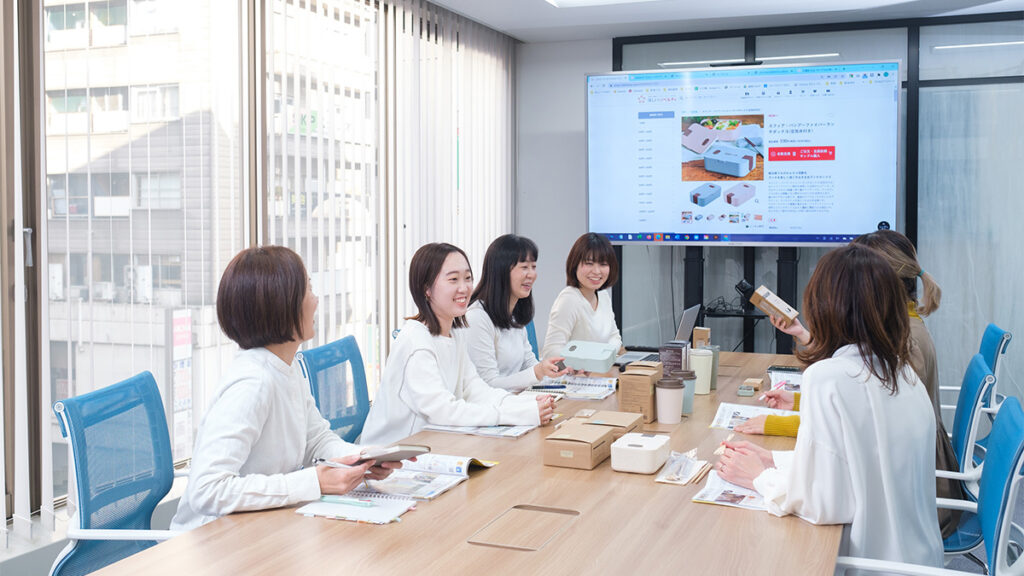 和やかな雰囲気で打ち合わせをしているスタッフの写真
