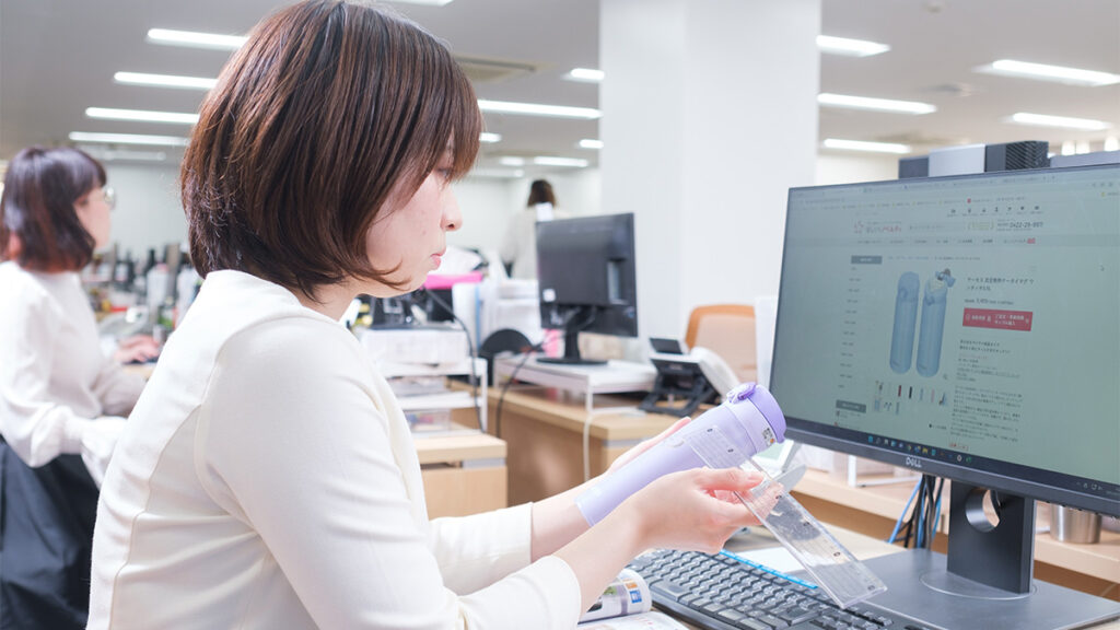 商品を手に取ってチェックをしているスタッフの写真